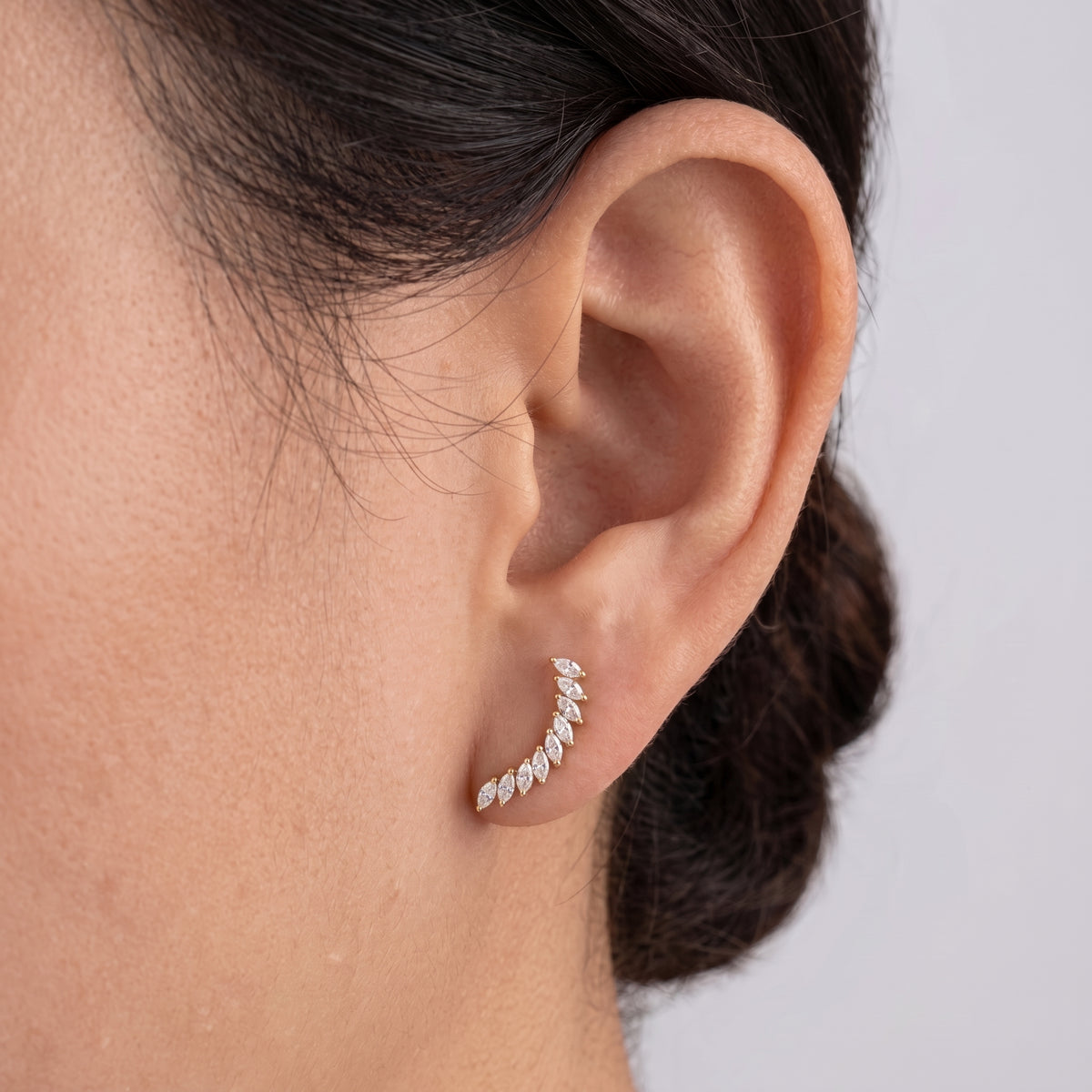 Close-up of Arcturus gold flat-back earring curving along the ear