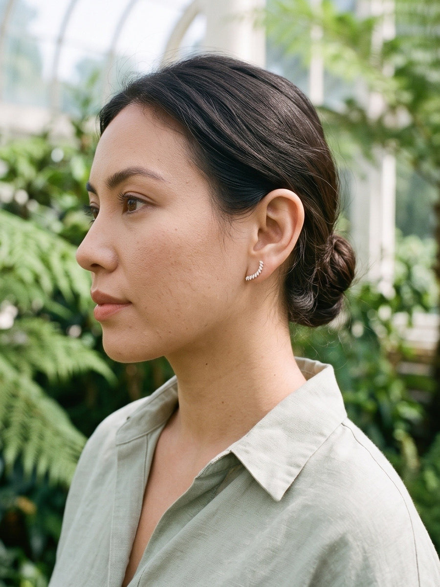 TISTELLA Arcturus gold flat back earring worn in a botanical glasshouse