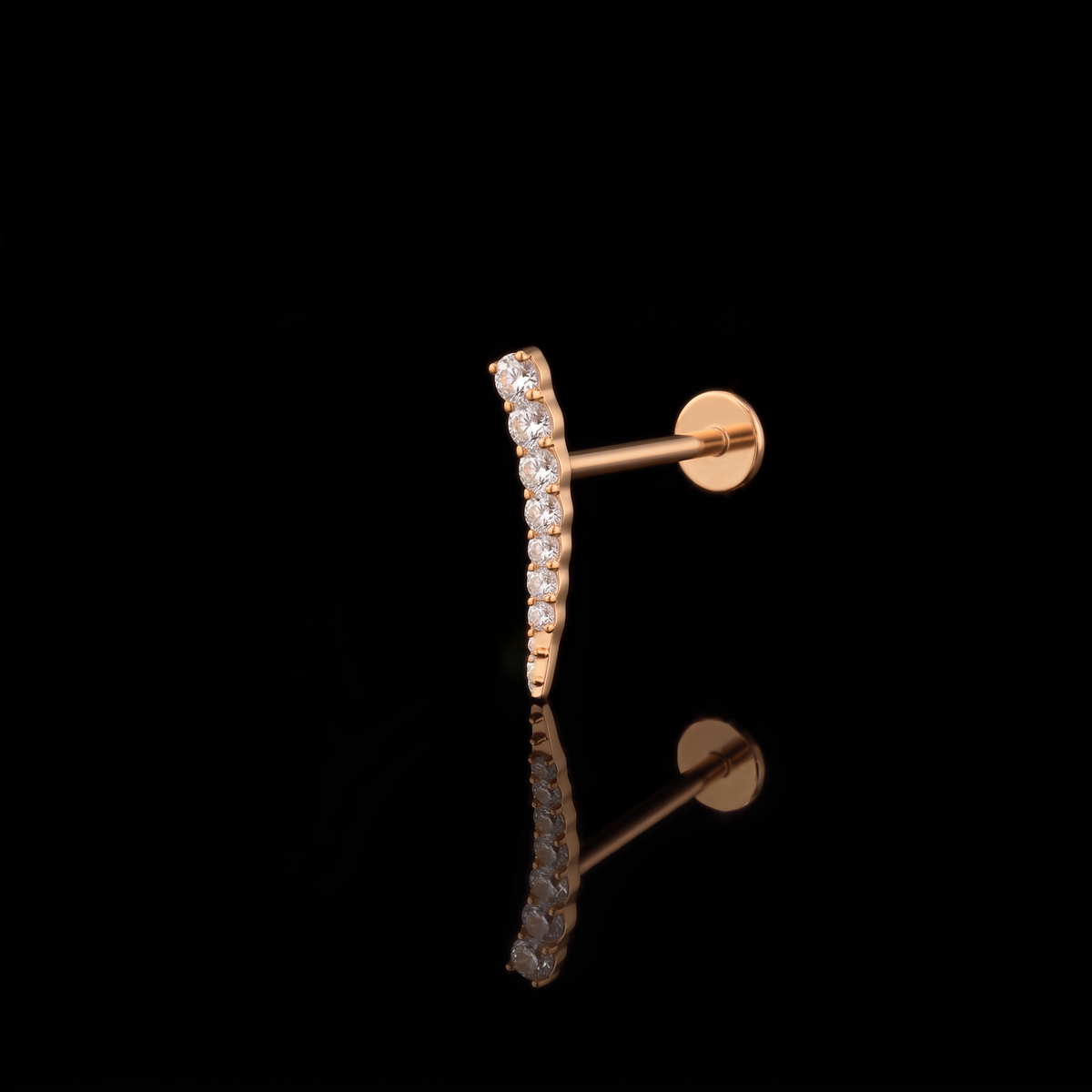 Aurora gold flat-back earring on a black reflective surface