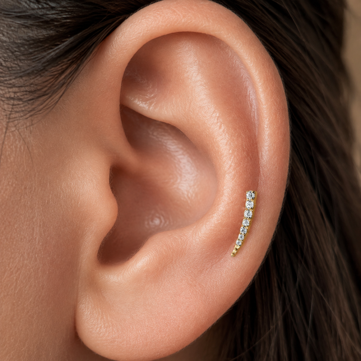 Close-up of Aurora gold flat-back earring following the line of the ear