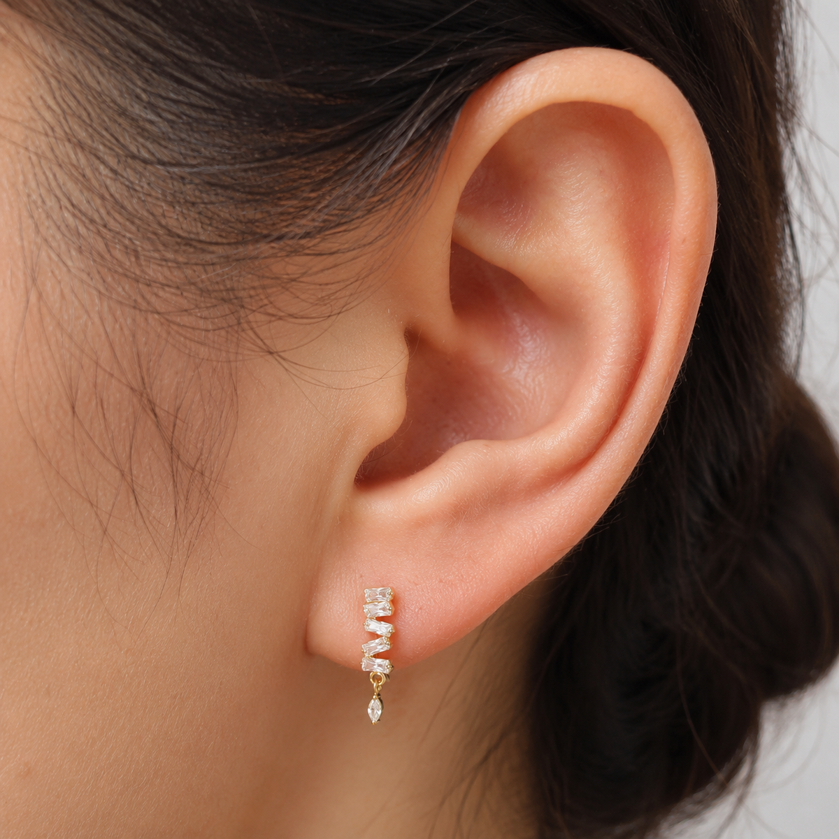 Close-up of Cadence gold flat-back earring showing the staggered baguette column