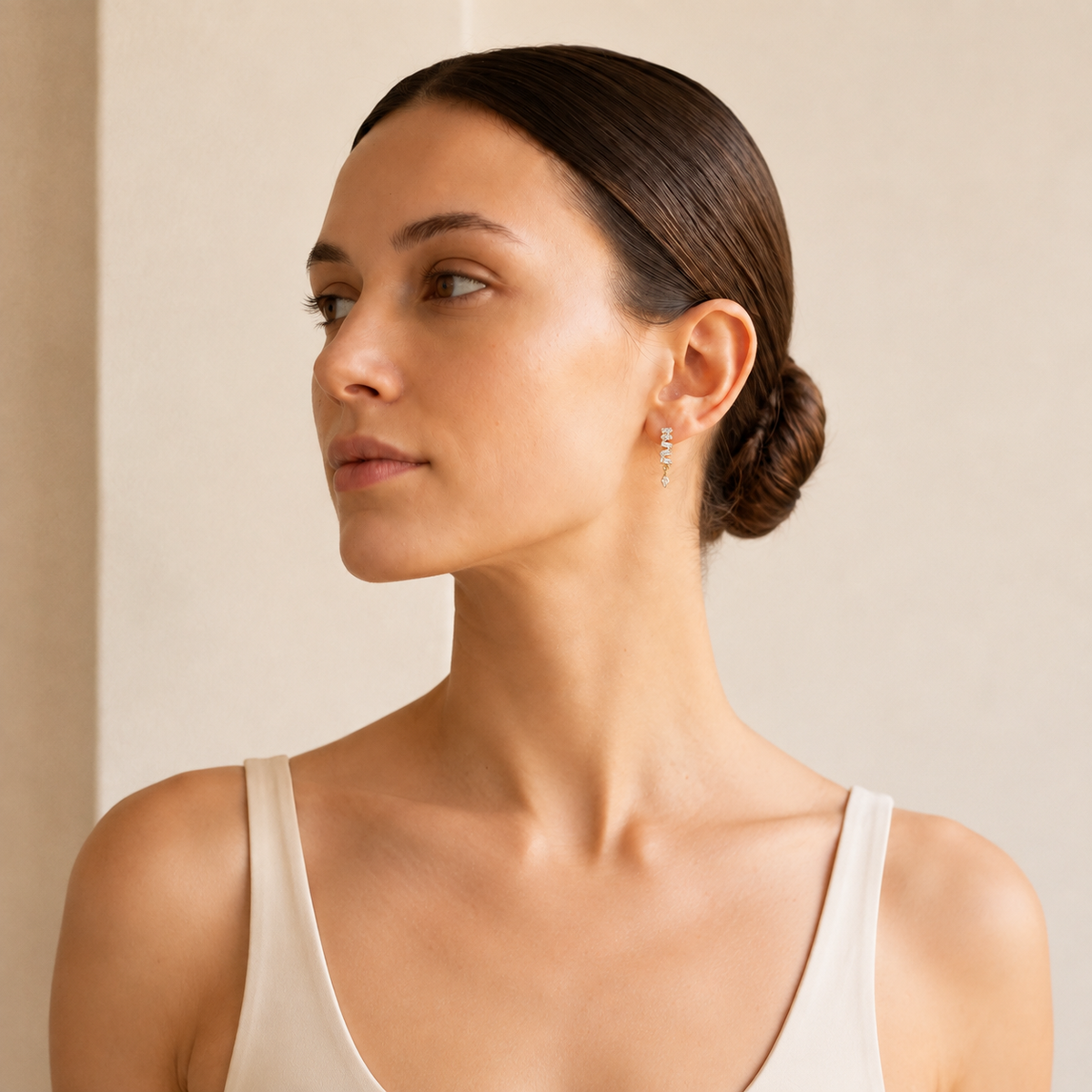 Woman wearing Cadence gold baguette flat-back earrings on her earlobe