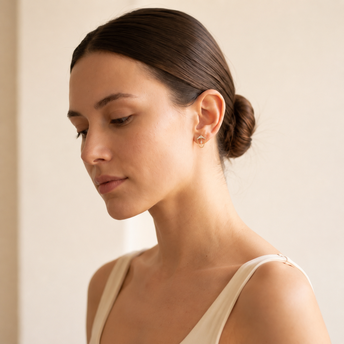 Woman wearing Diadem gold flat-back earrings on her earlobe