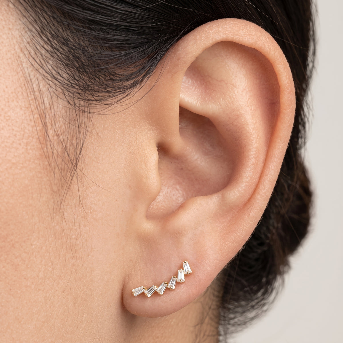 Close-up of Glacia gold flat-back earring curving along the ear
