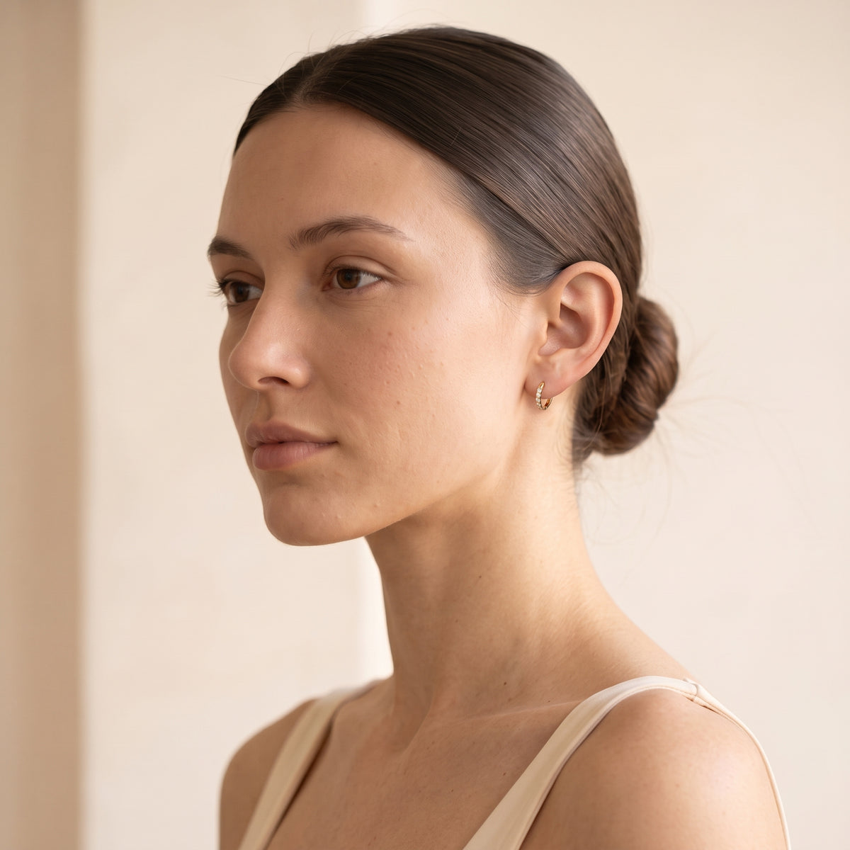 Woman wearing Halo 10mm gold hoop earrings