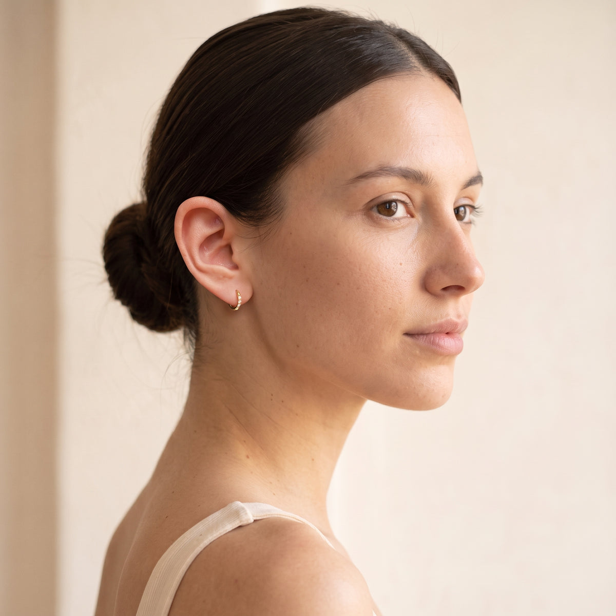 Woman wearing Halo 8mm gold hoop earrings