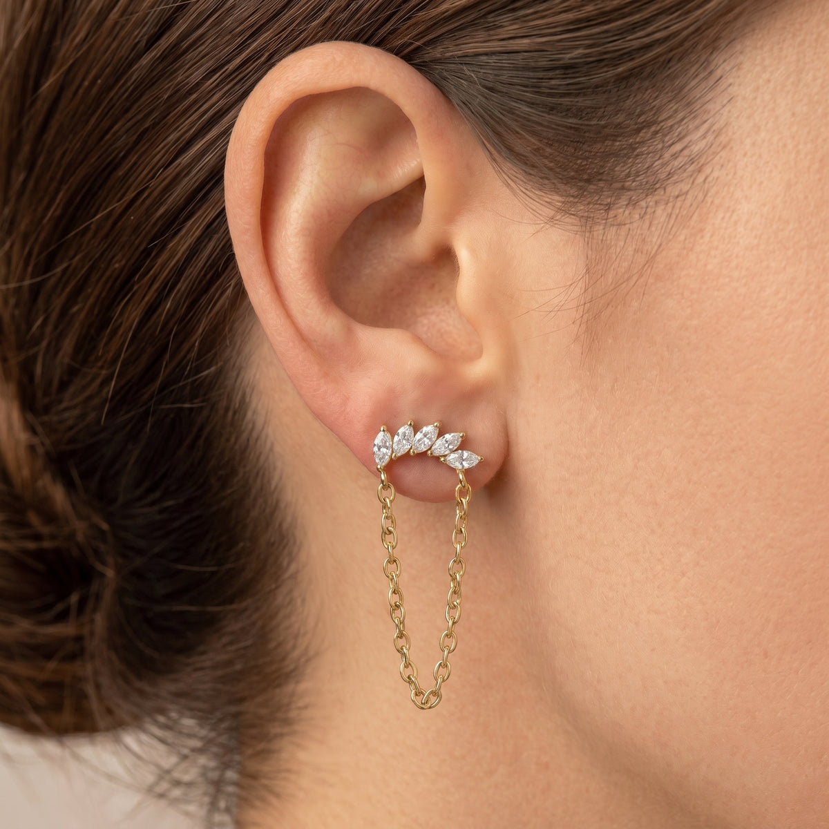 Close-up of Lyra gold flat-back earring, chain falling below the lobe